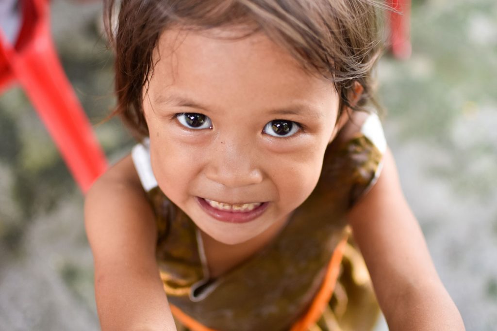 Happy child looking at a staff from Childhope, an NGO for children in the Philippines