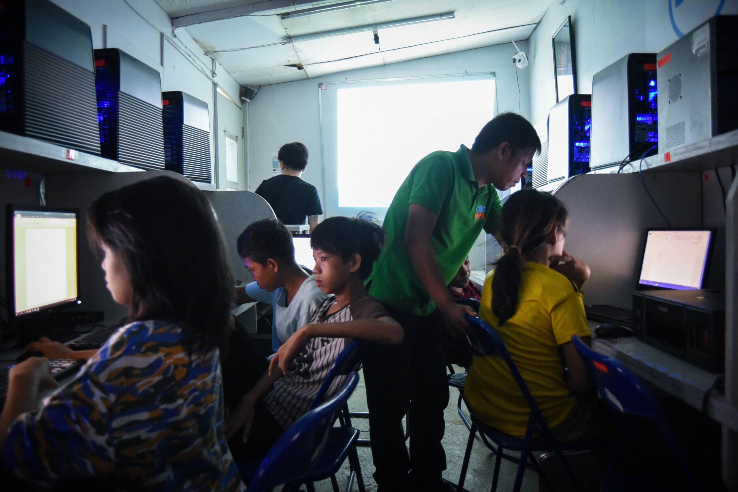 Street educator teaching street children how to use a computer