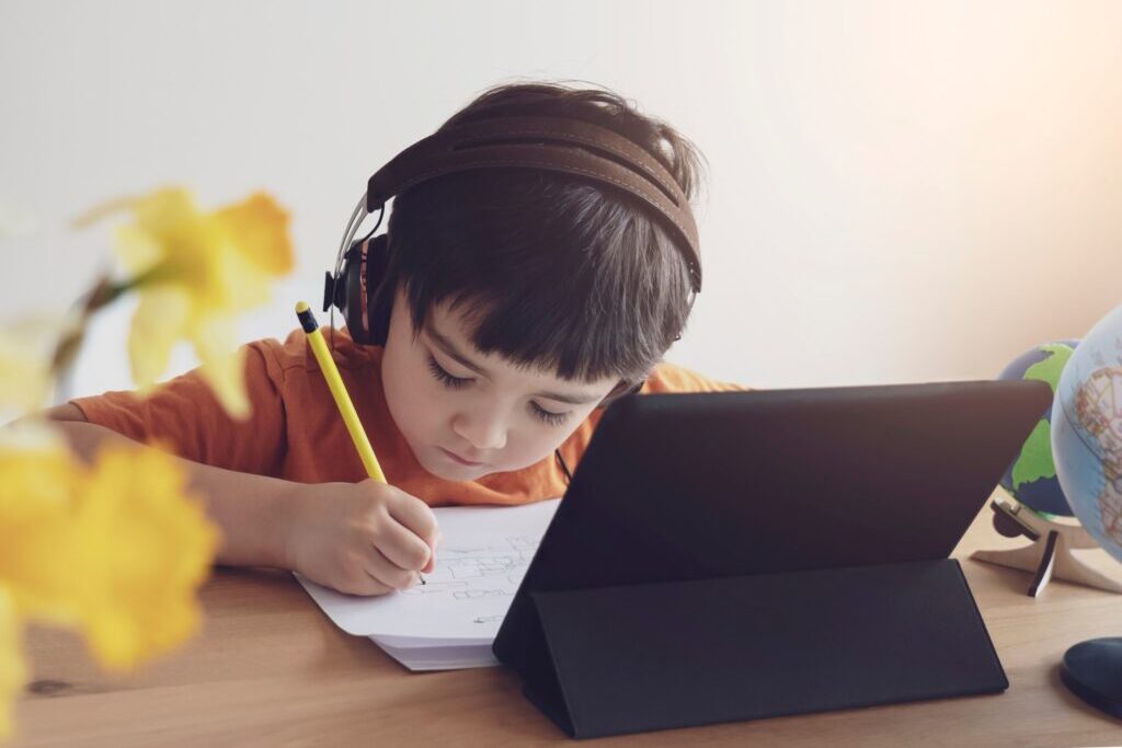 kid using tablet for his homework under new normal in education