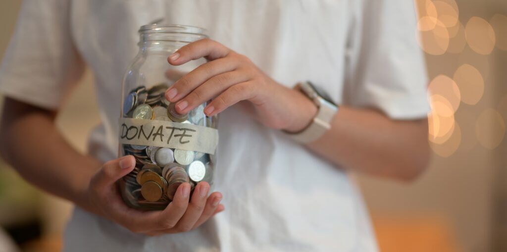 man holding jar to use as donation for children