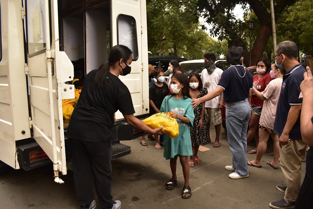 Volunteer from Childhope Philippines giving relief package function of NGO