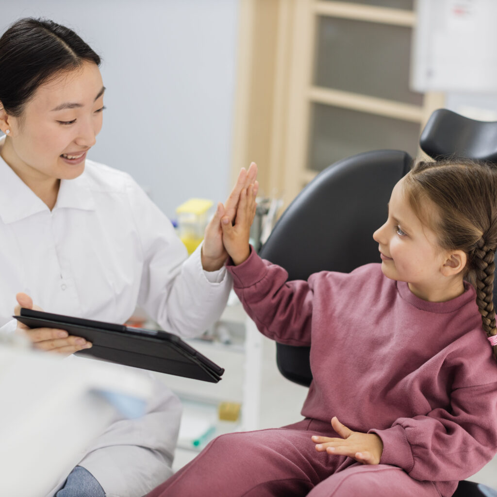 dentist giving high five to little girl