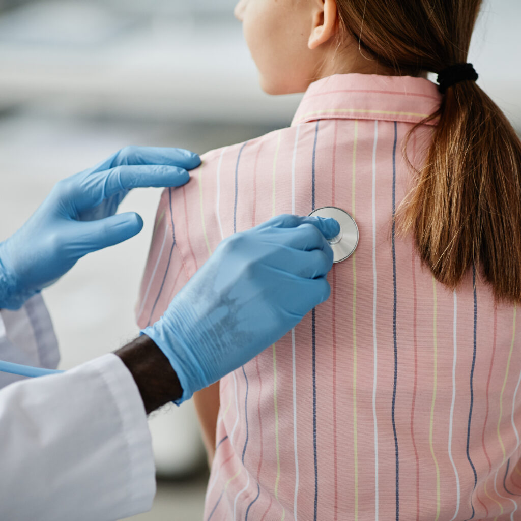 pediatrician examining child in clinic