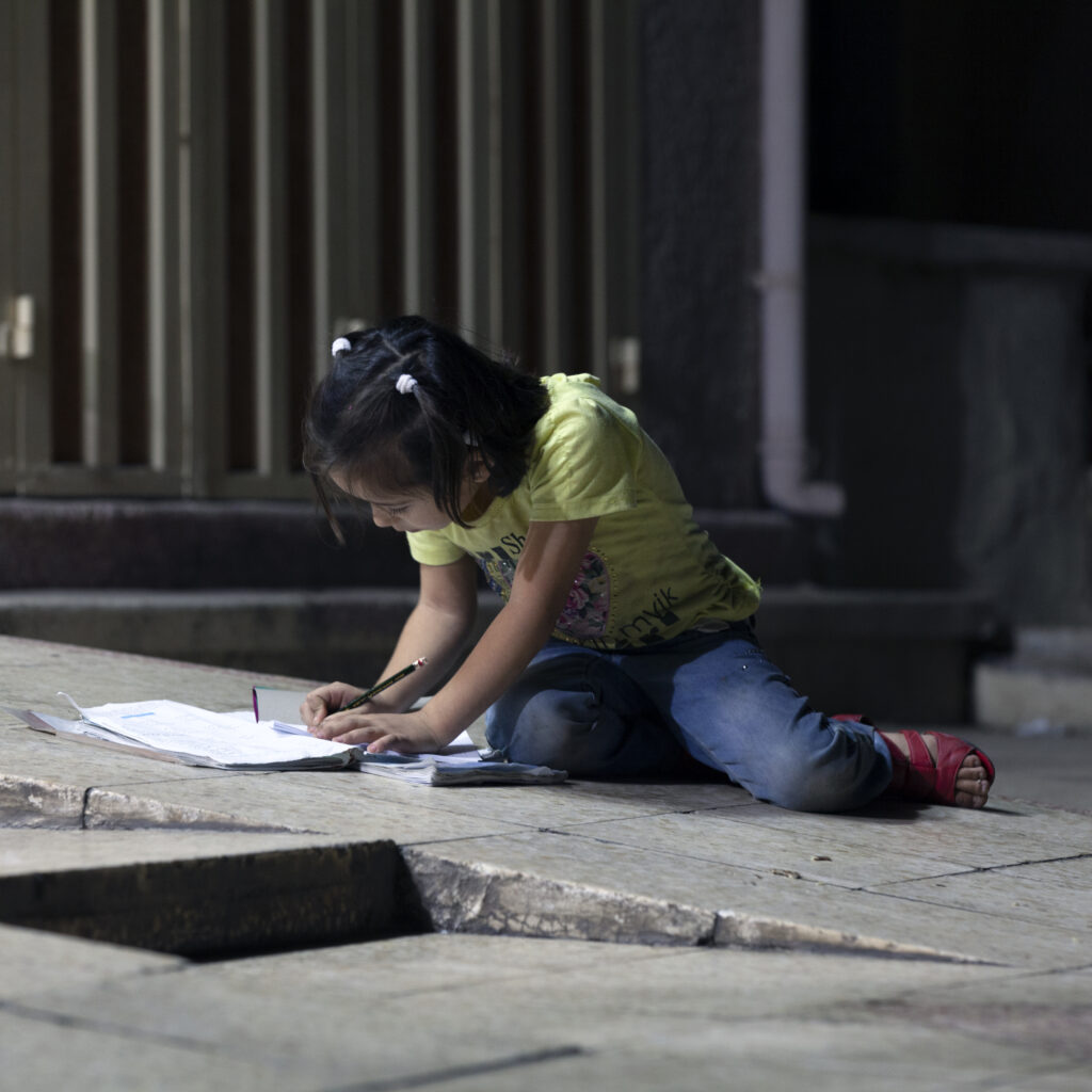 Child studying using street light