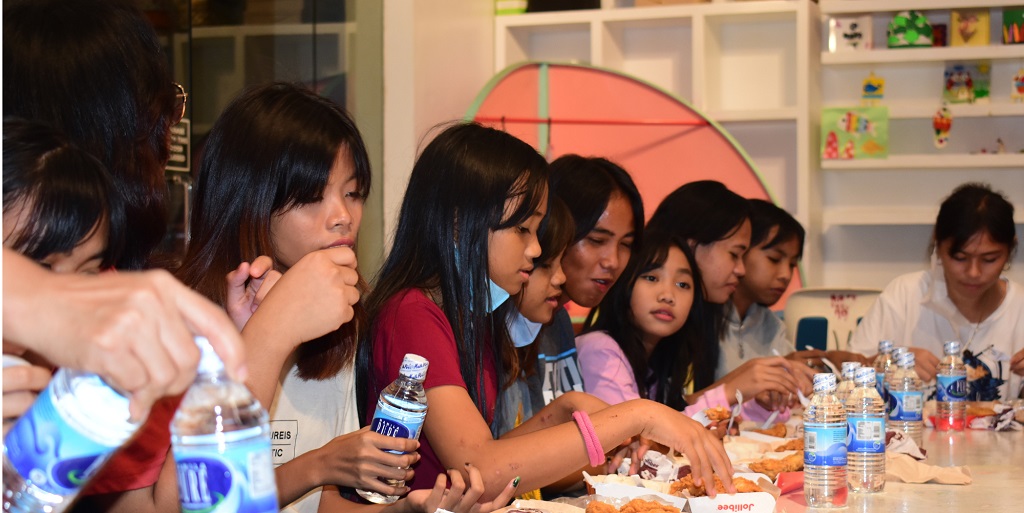 Children eating Jollibee after the benefit concert
