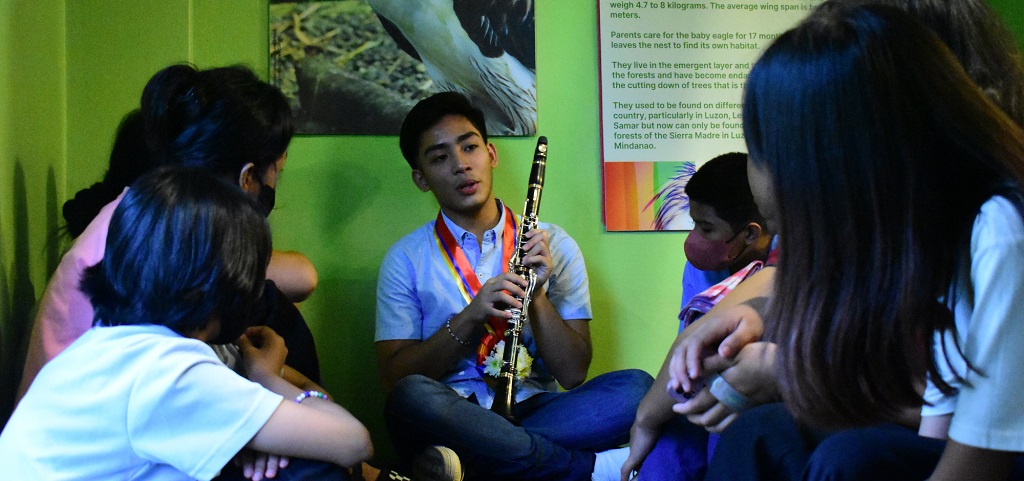 clarinetist Franz Andra showing children the basics of clarinet 