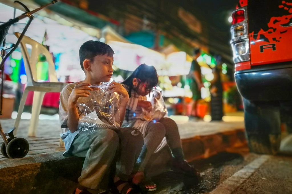 Filipino street children eating on the side walk