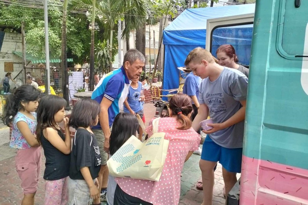 youth volunteer distributing food to street children