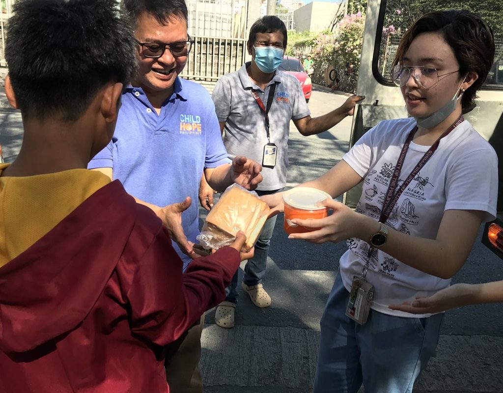 student volunteers distributing food to street children