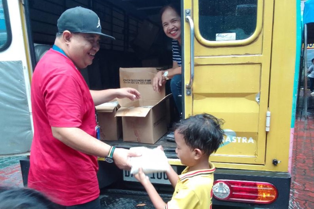 Childhope staff giving a donation to a child