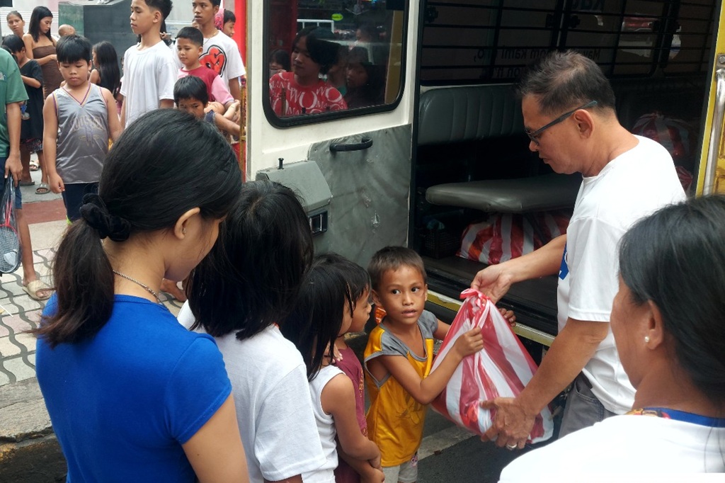 volunteers giving donations to children in street situations