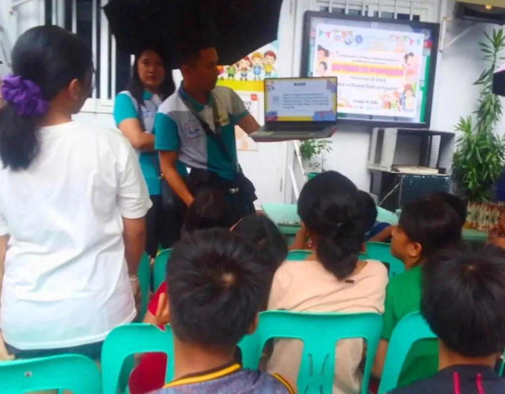 childhope co-teacher showing presentation on a laptop