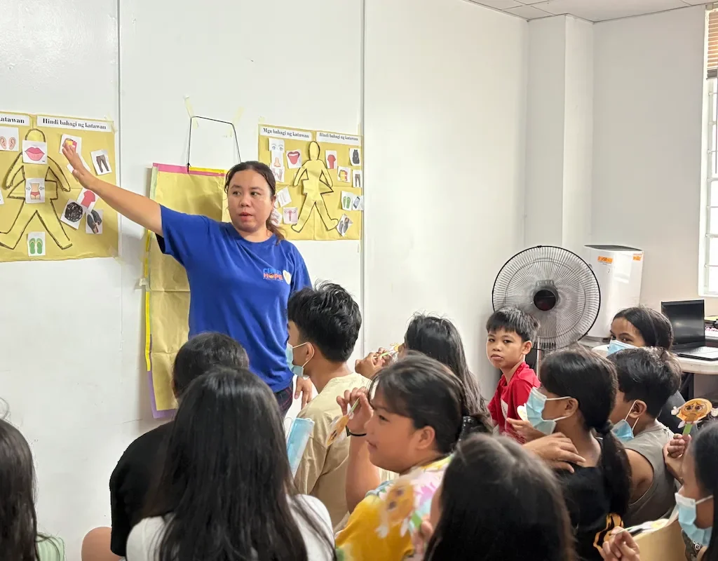 childhope female co-teacher teaching body parts