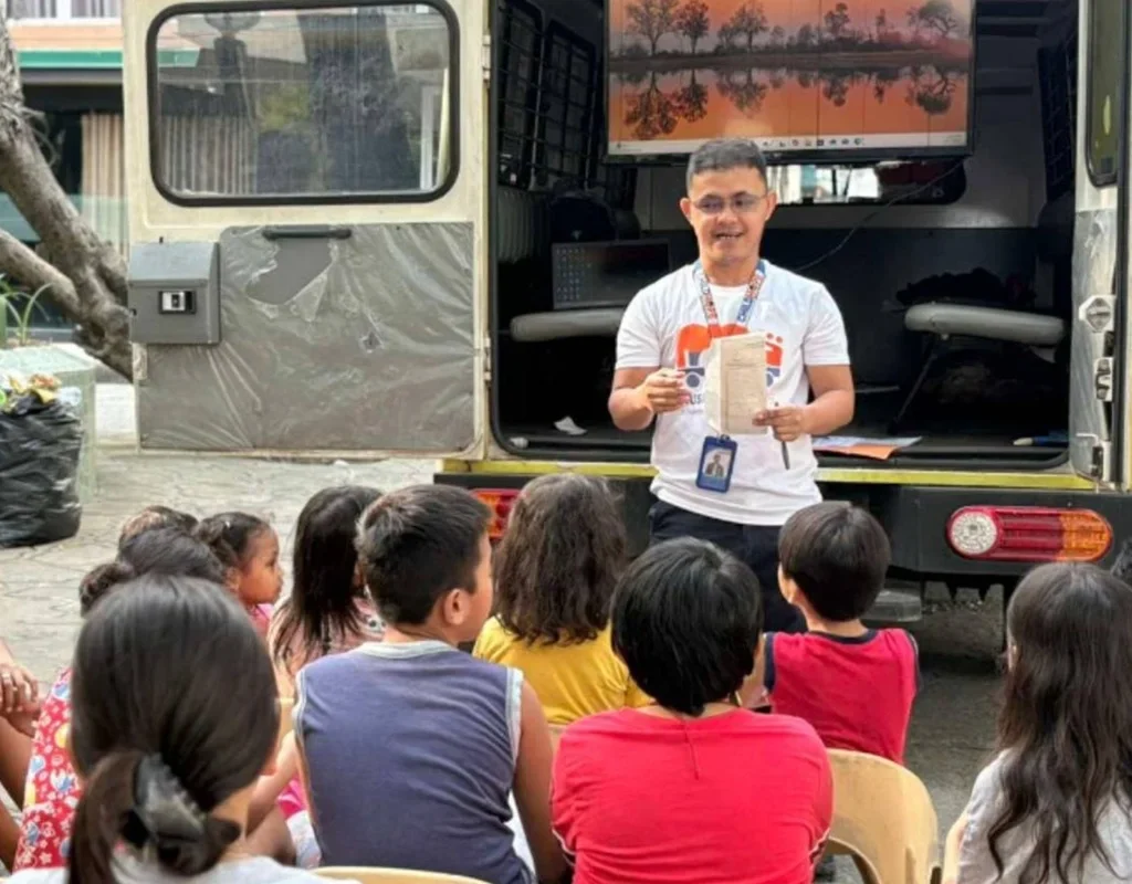 teacher conducting a community-based education session with children on the streets