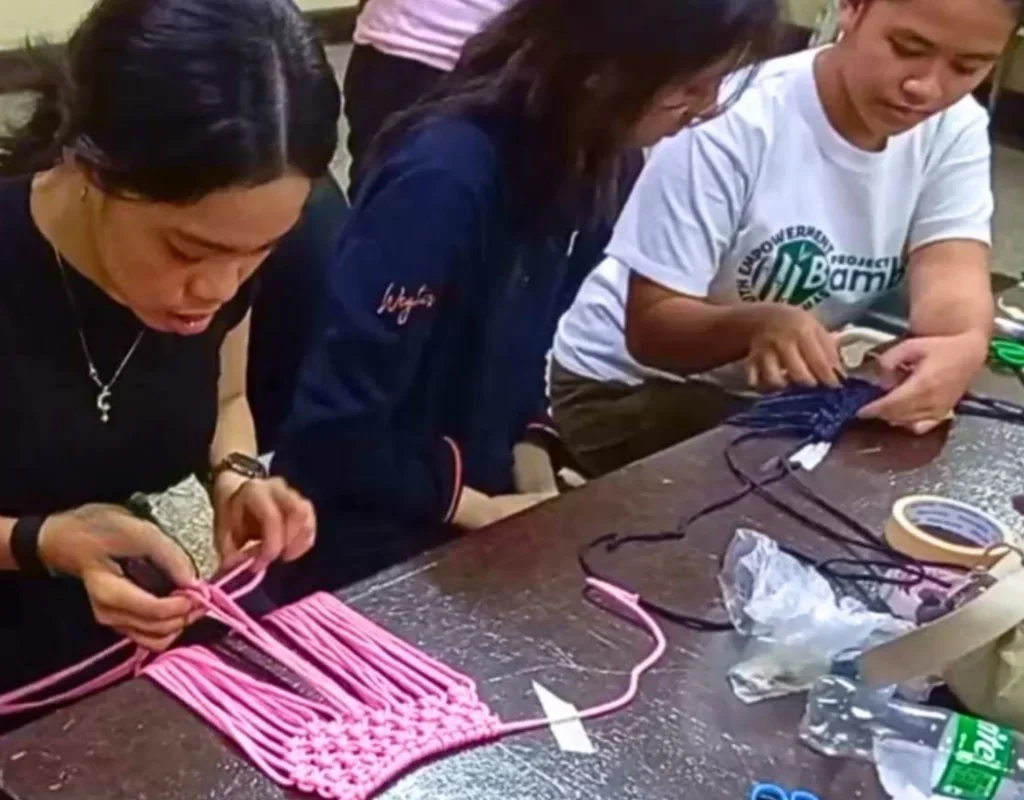 trainer guides intern on macrame workshop
